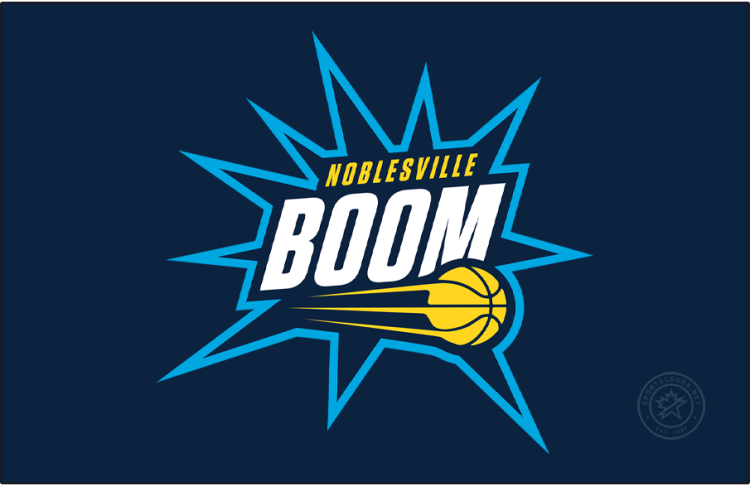 Noblesville Boom Logo Primary Dark Logo (2025/26-Pres) - The Noblesville Boom logo features a navy blue blast trimmed in cyan, with the team name displayed across it in white and yellow. The streaking yellow basketball from their NBA affiliate, the Indiana Pacers, is placed near the bottom of this blast or boom shape. SportsLogos.Net