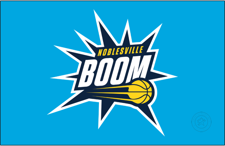 Noblesville Boom Logo Primary Dark Logo (2025/26-Pres) - The Noblesville Boom logo features a navy blue blast trimmed in cyan, with the team name displayed across it in white and yellow. The streaking yellow basketball from their NBA affiliate, the Indiana Pacers, is placed near the bottom of this blast or boom shape. SportsLogos.Net