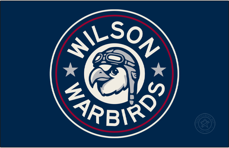 Wilson Warbirds Logo Primary Dark Logo (2026-Pres) - The Wilson Warbirds logo shows an eagle wearing an old-fashioned aviator helmet on a blue and red roundel. SportsLogos.Net